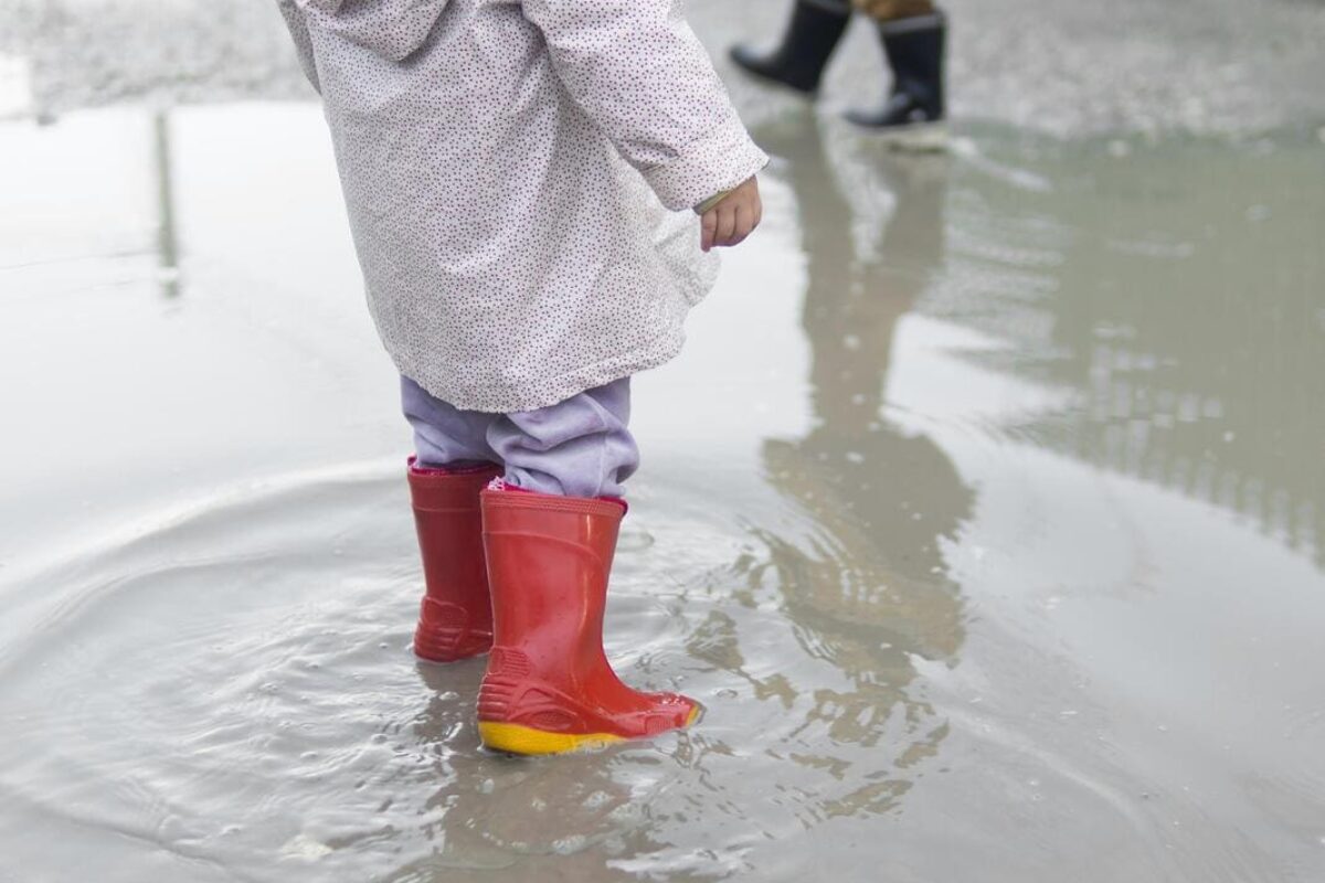 child-wearing-boots-sitting-water