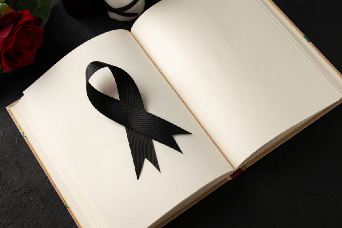 top-view-open-book-with-black-mourning-bow-dark-wall