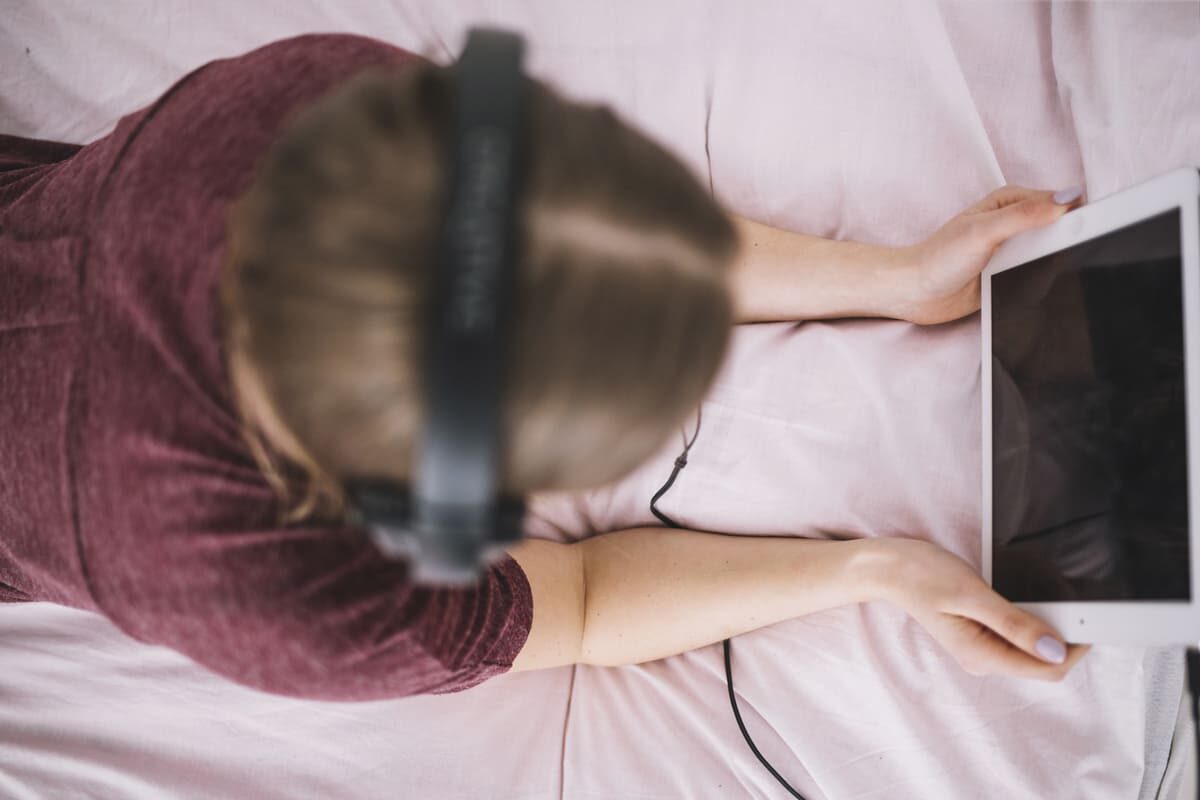 unrecognizable-woman-using-tablet-bed