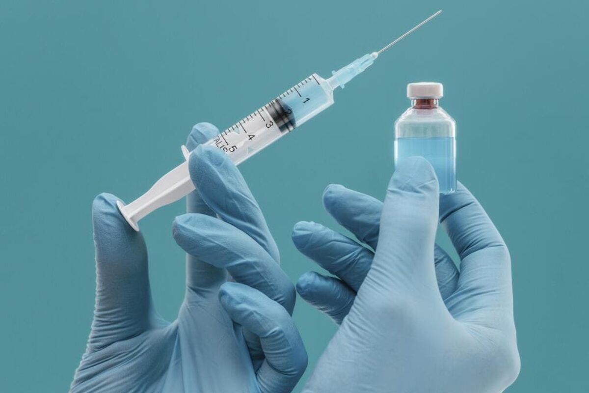 vaccine-bottle-syringe-held-by-doctor-with-gloves