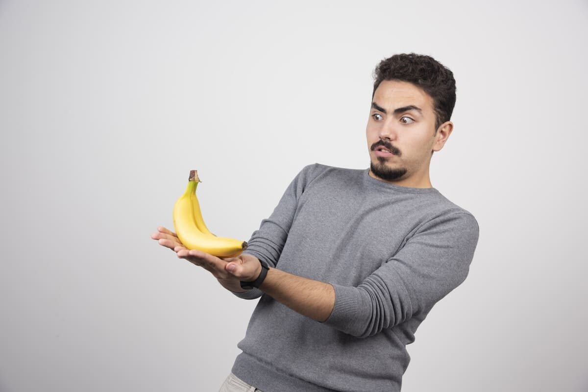young-man-looking-banana-gray