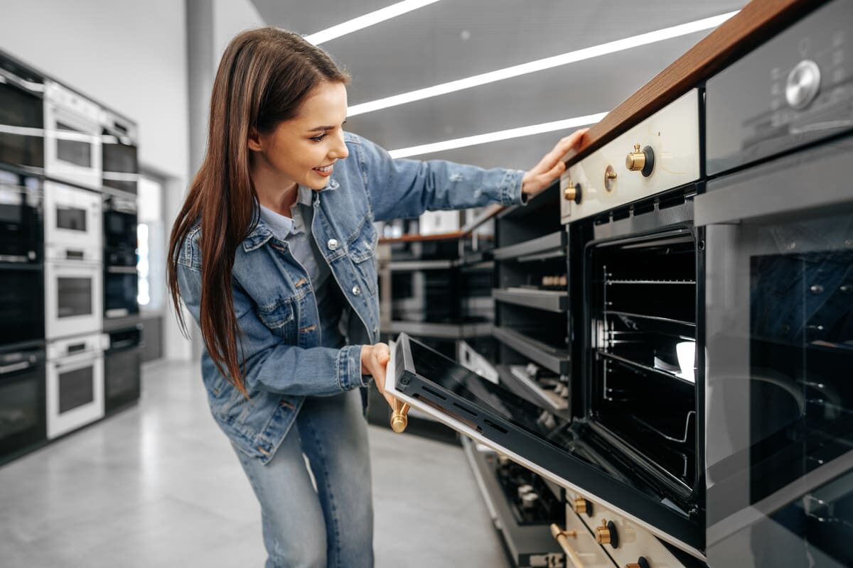 young-woman-looking-new-electric-oven-shopping-mall